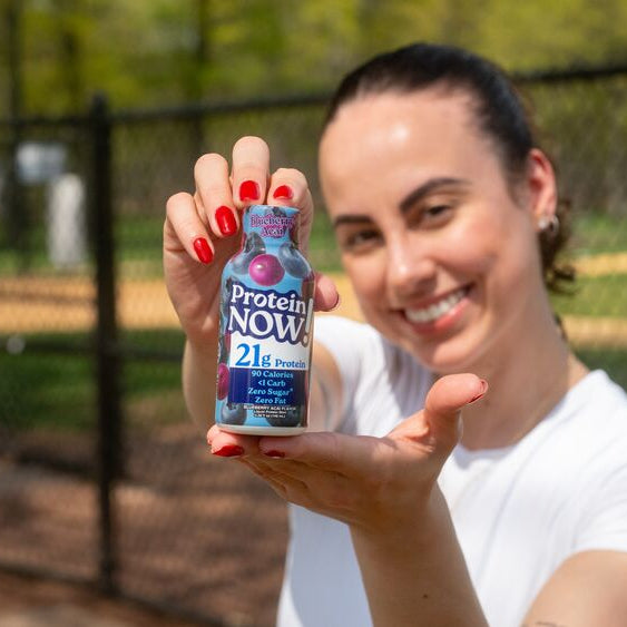 female holding protein now shot in outdoor scene